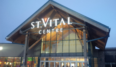 An external photo of St. Vital Centre's entrance in the evening