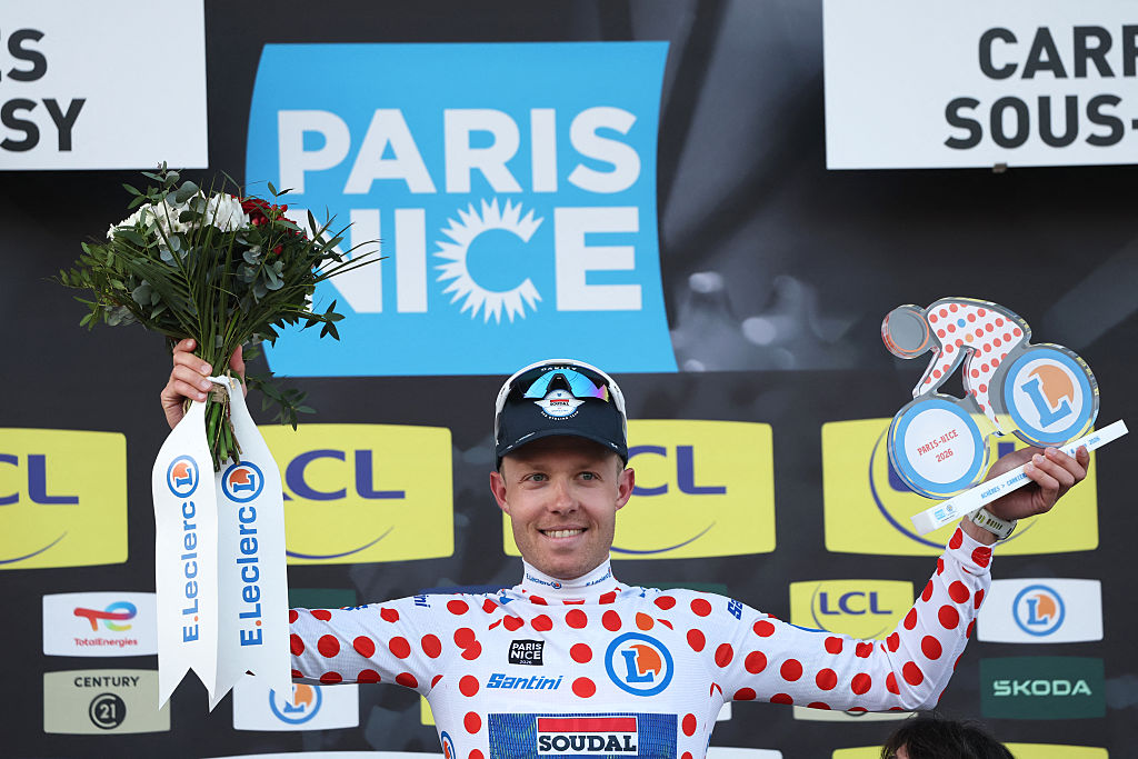 Soudal Quick-Step's Danish rider Casper Pedersen celebrates his white with red polka dots jersey for best climber on the podium after the 1st stage of the Paris-Nice cycling race, 170.9 km between Ach&egrave;res and Carri&egrave;res-sous-Poissy, on March 8, 2026. (Photo by Anne-Christine POUJOULAT / AFP)