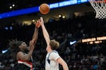 Portland Trail Blazers guard Jrue Holiday (5) shoots as Dallas Mavericks forward Cooper Flagg defends shoot during the second half of an NBA basketball game Friday, March 27, 2026, in Portland, Ore.