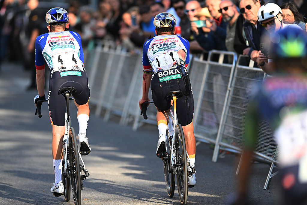 Evenepoel and teammate Luke Tuckwell pictured from behind with tears to Evenepoel's jersey evident