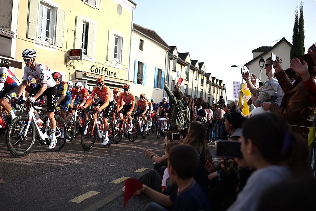 Spectators wave at riders during the 1st stage of the Paris-Nice cycling race, 170.9 km between Ach&egrave;res and Carri&egrave;res-sous-Poissy, on March 8, 2026. (Photo by Anne-Christine POUJOULAT / AFP)