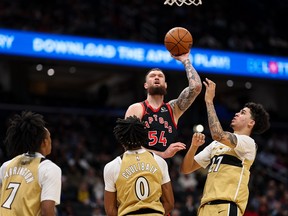 Toronto's Sandro Mamukelashvili shoots the ball in front of Washington's Bub Carrington (7), Bilal Coulibaly (0), and Will Riley (27) at Capital One Arena on Saturday in Washington, DC.