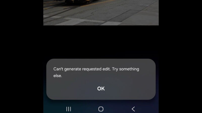 A smartphone screen displays a pop-up message saying, "Can't generate requested edit. Try something else." with an "OK" button below. The background shows a street scene partially visible at the top.