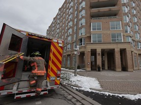Toronto Fire trucks sit parked outside two condo buildings.