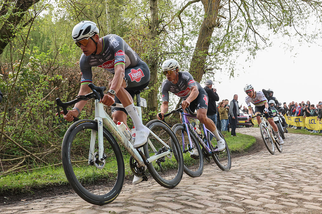 Alpecin-Deceuninck's Dutch rider Mathieu van der Poel (L), Alpecin-Deceuninck's Belgian rider Jasper Philipsen and UAE Team Emirate's Slovenian rider Tadej Pogacar (R) cycle in a breakaway on a cobblestone road during the 122nd edition of the Paris-Roubaix one-day classic cycling race, 259,2 km between Compiegne and Roubaix, northern France on April 13, 2025. (Photo by Francois LO PRESTI / AFP)