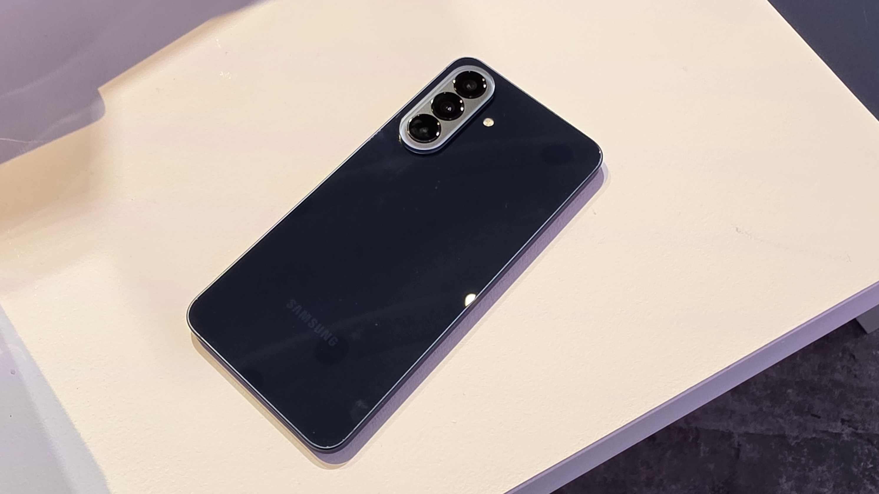 The Samsung Galaxy A57 face down on a table, in its Navy model.