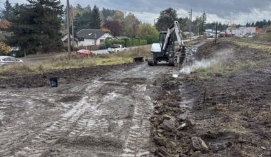 A muddy path in the foreground with a digger in the background