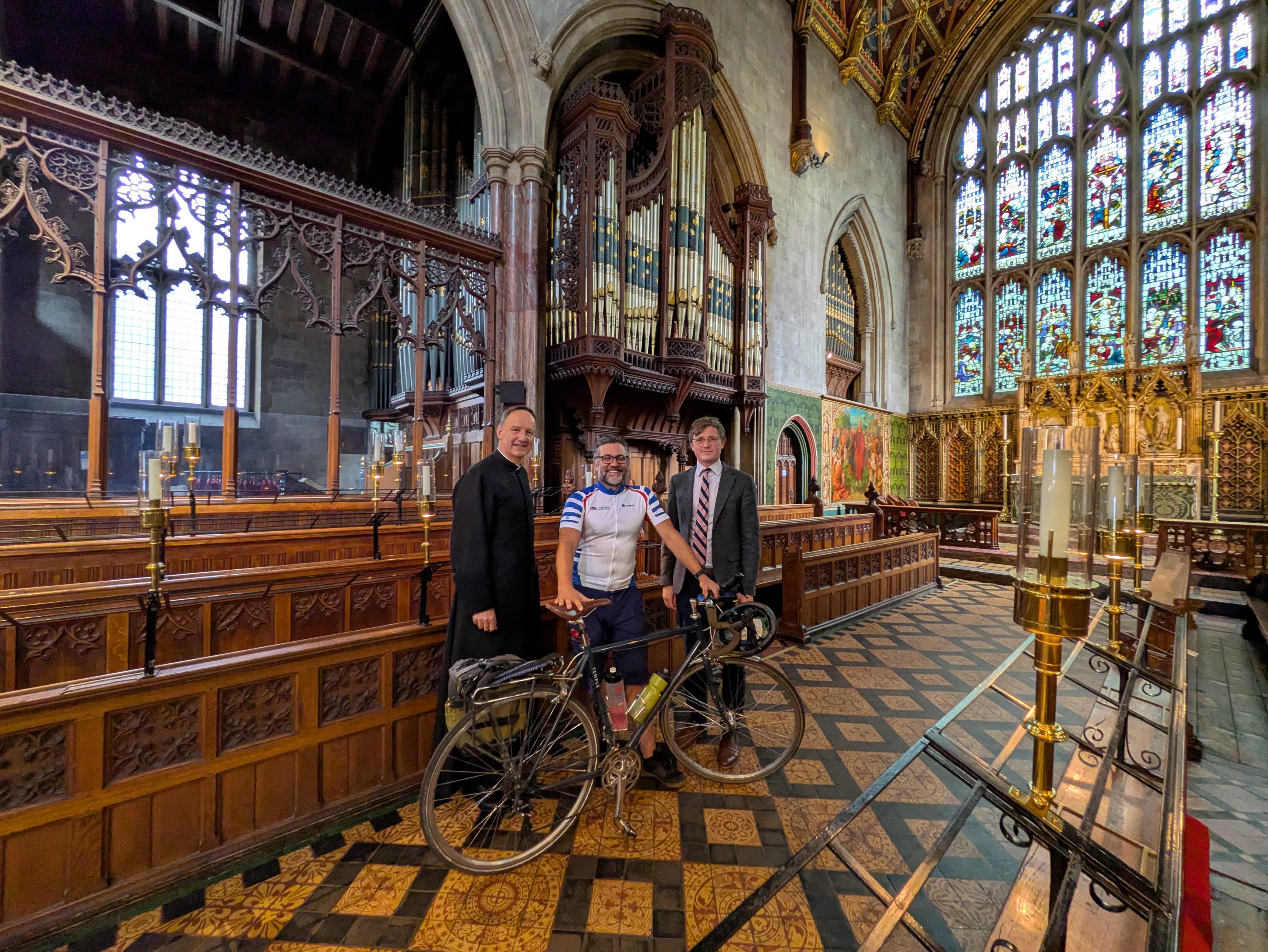 Men stand in cathedral with bike