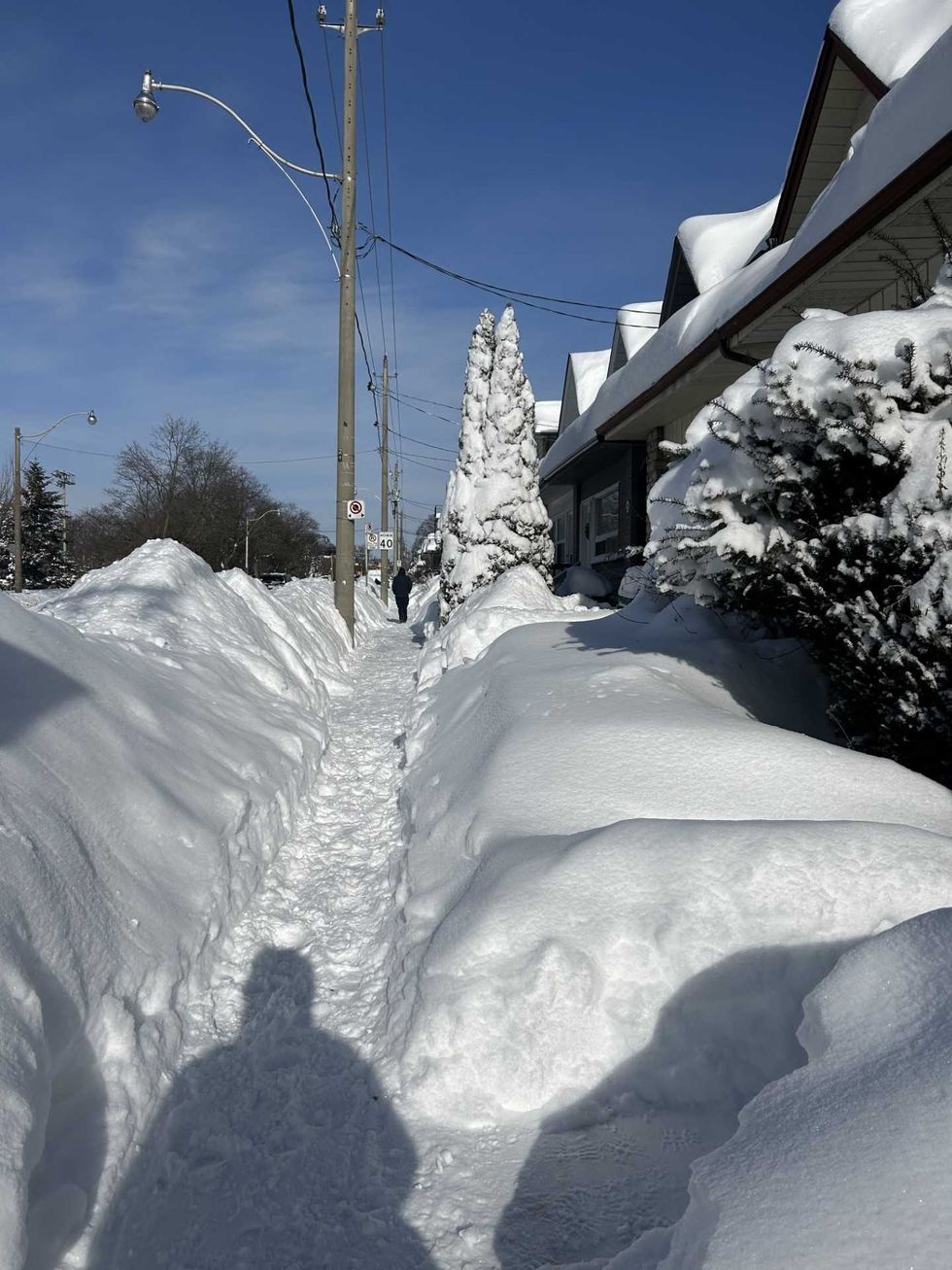 A narrow path with snowbanks either side.