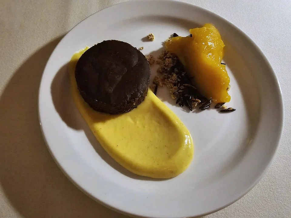 A dark chocolate fondant on brown butter pastry cream and squash sorbet on a bed of puffed wild rice, adding an unexpected crunch to close out the meal.