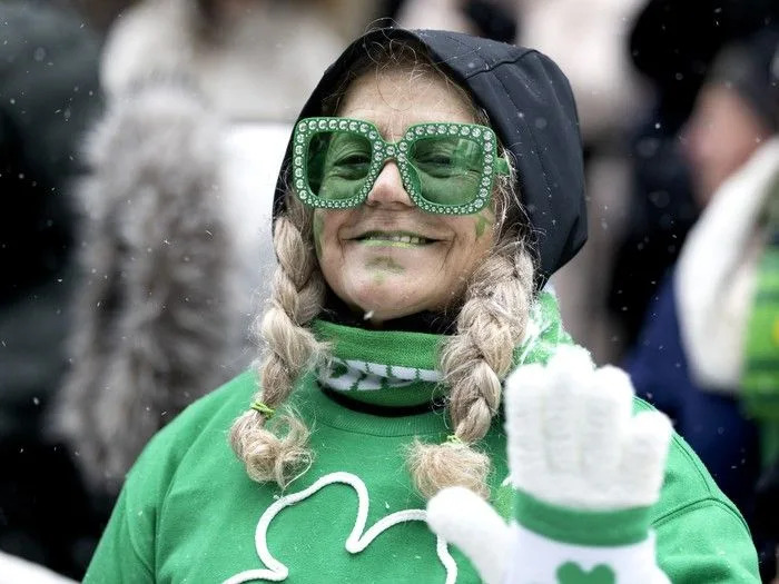  A spectator braves the steady snowfall to watch the St. Patrick’s Parade in Montreal on Sunday, March 22, 2026.
