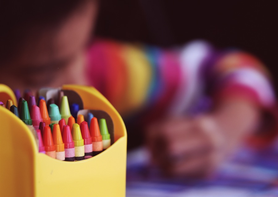 aaron-burden-crayons-unsplash - Ottawa Road Trips crayons in foreground with child colouring in background