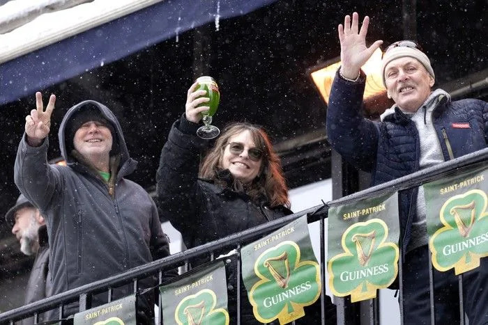  Equipped with green beer, spectators offer cheers from a balcony as they watch the St. Patrick’s Parade in Montreal on Sunday, March 22, 2026.