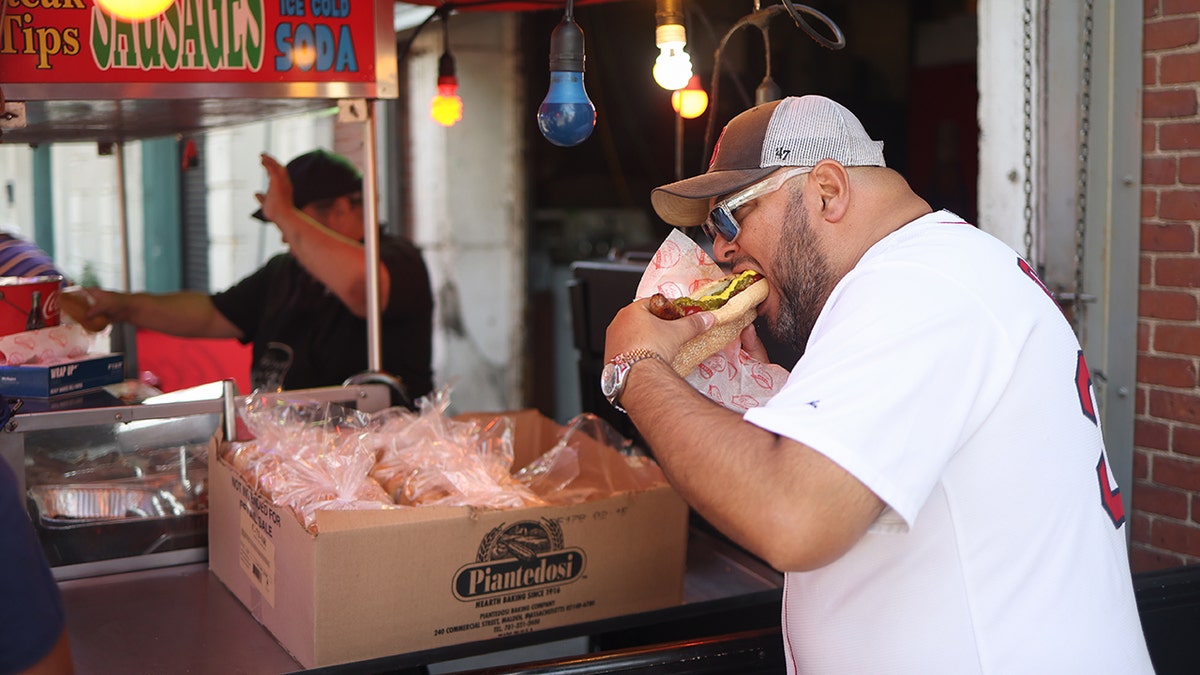 A fan eats a hotdog outside of the stadium prior to the game between the Toronto Blue Jays and the Boston Red Sox at Fenway Park on Friday, June 27, 2025 in Boston, Massachusetts.