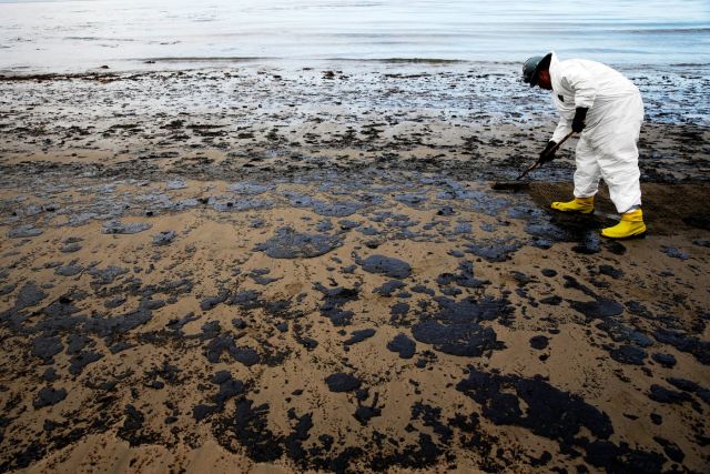 FILE - A worker removes oil from sand at Refugio State Beach, north of Goleta, Calif., on May 21, 2015. (AP Photo/Jae C. Hong, File, File)