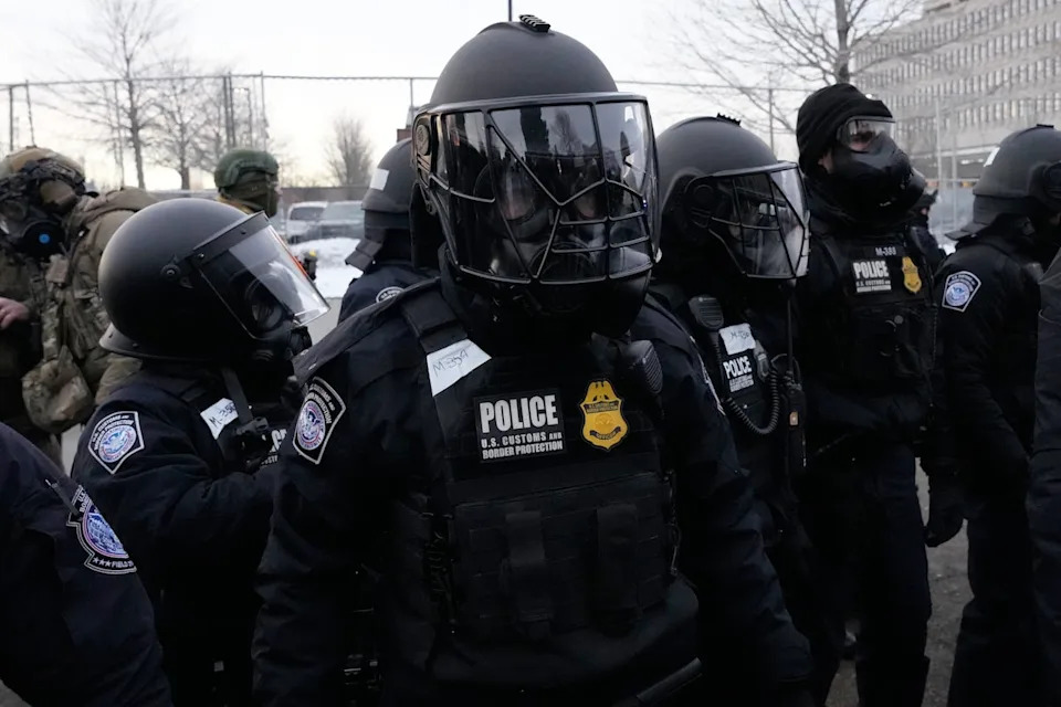 U.S. Customs and Border Protection police officers stand outside the Bishop Henry Whipple Federal Building during a protest on Saturday, Jan. 17, 2026, in Minneapolis. (AP Photo/Yuki Iwamura)