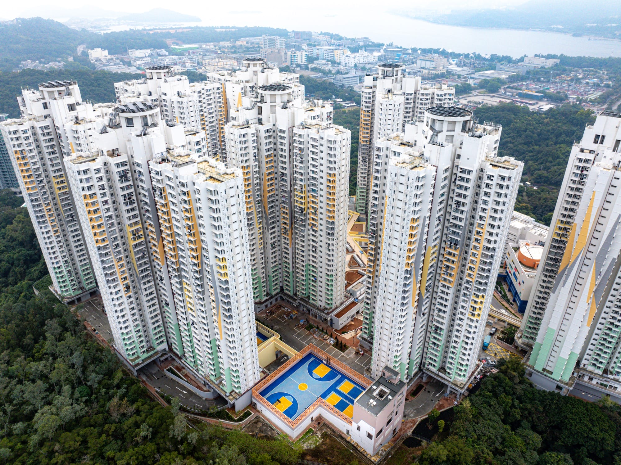 A colorful basketball court amid tall buildings in Hong Kong