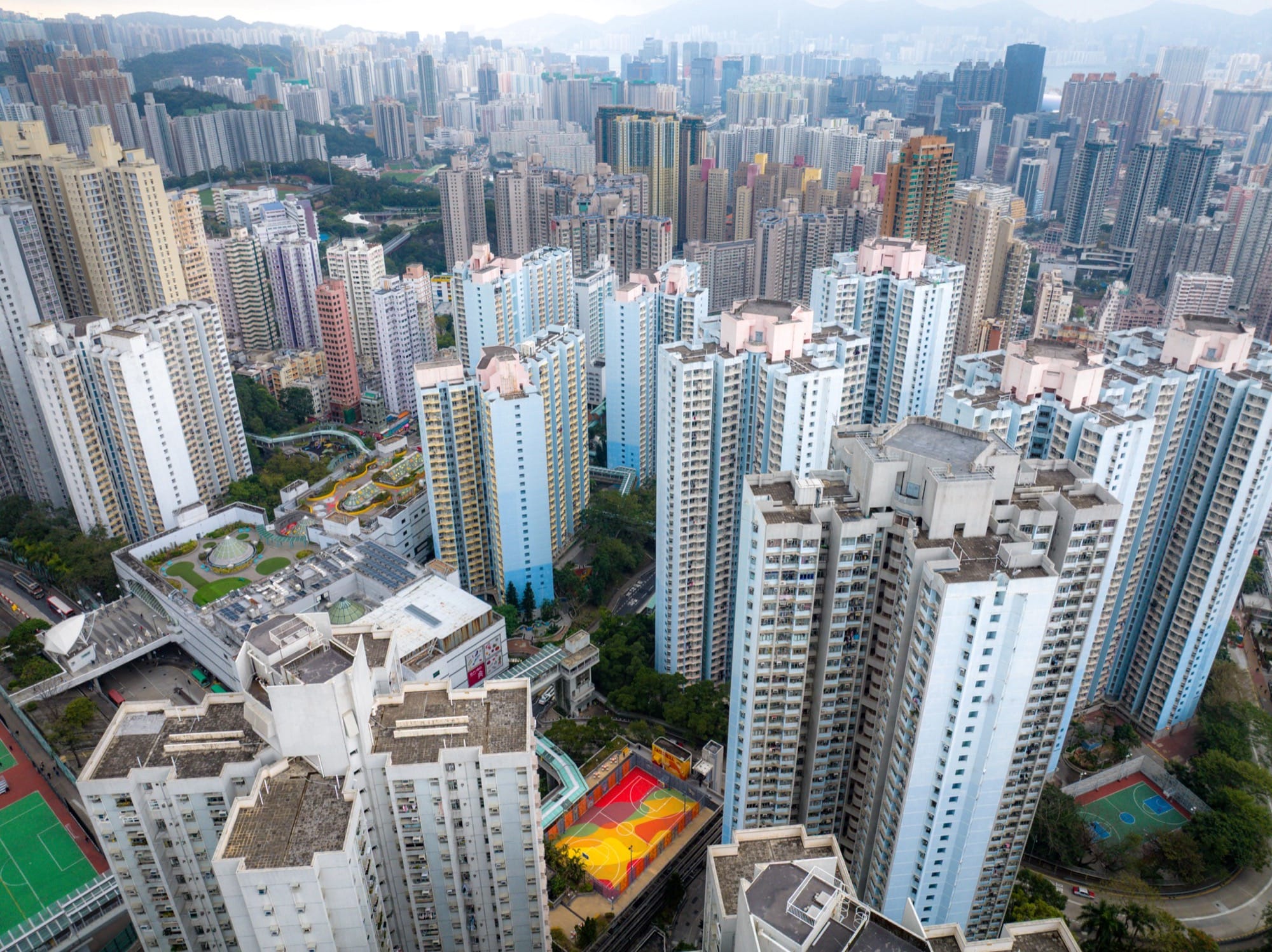 A colorful basketball court amid tall buildings in Hong Kong