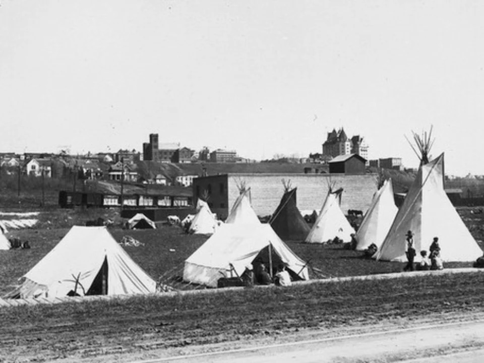 Dated in 1919, tents and teepees set up in Rossdale next to the Hudson’s Bay Company barns; buildings visible in the background include the Macdonald Hotel, McDougall Church, Blowey Henry building, Edmonton Club as well as the E.Y. & P. Railway. People and horses are also near the tents and teepees. Supplied Photo/City of Edmonton Archives