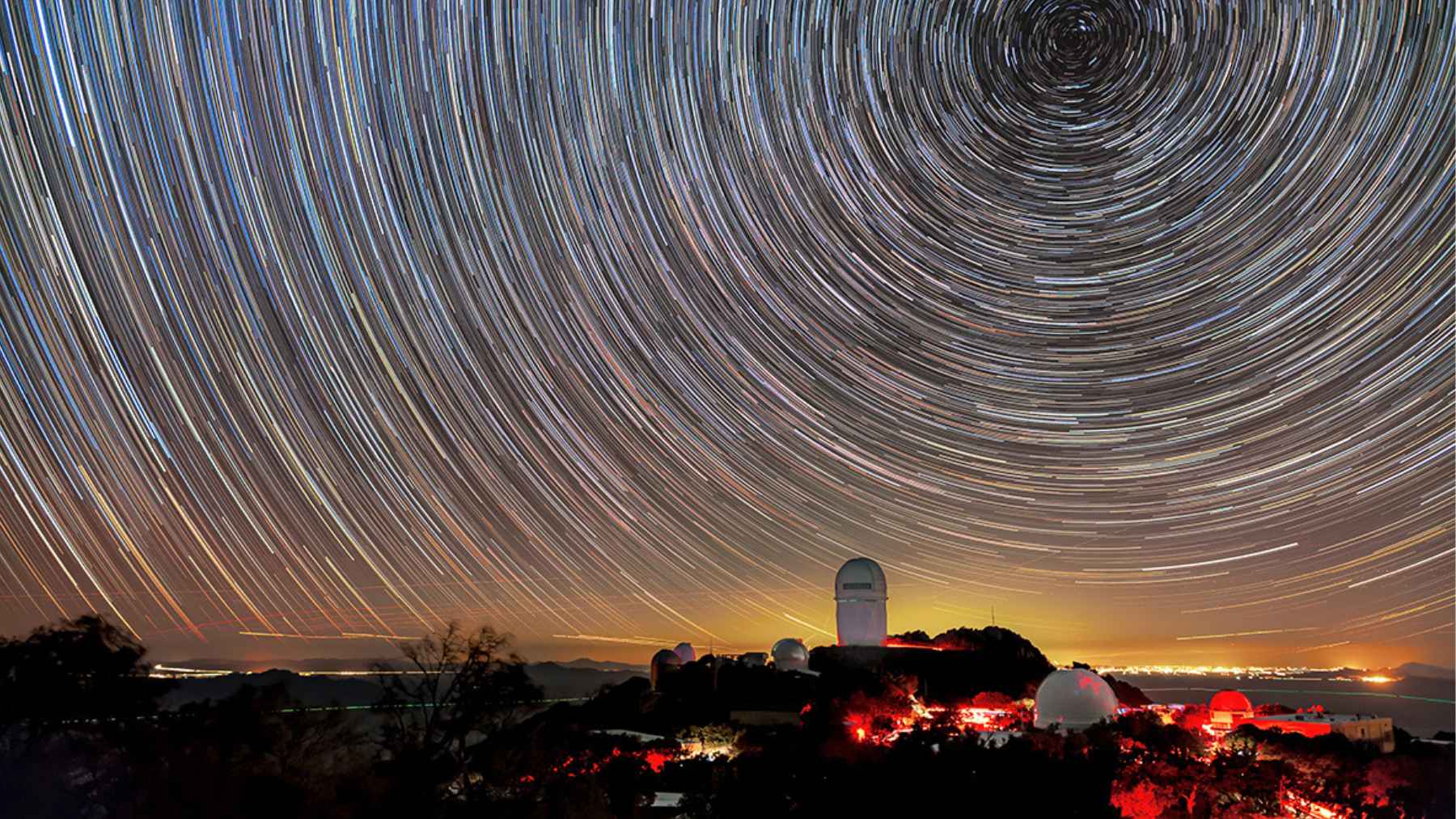 Star trails above an astronomical observatory as scientists revisit the Big Crunch theory and the fate of the universe