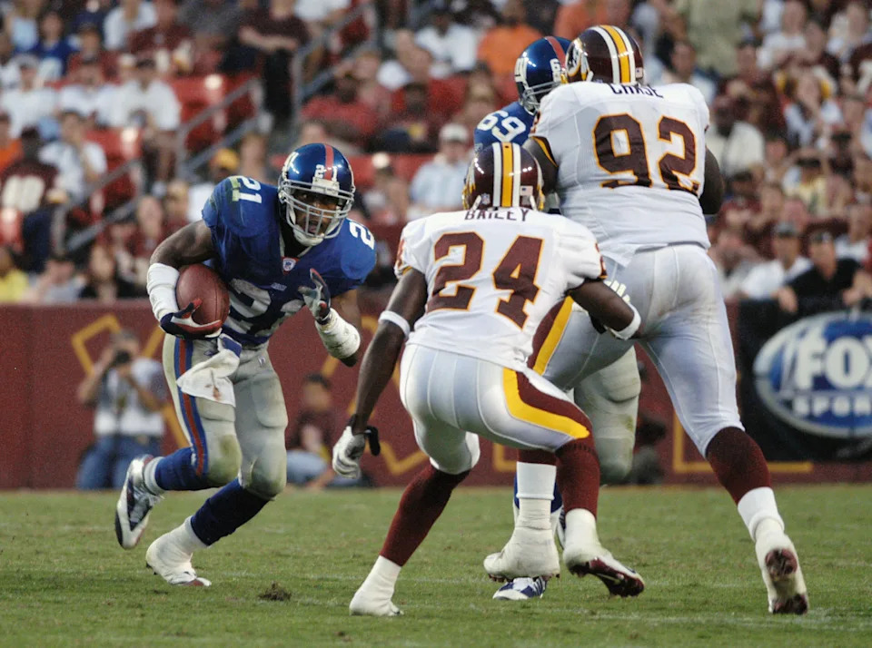 Tiki Barber #21 of the New York Giants carries the ball as Champ Bailey defends.