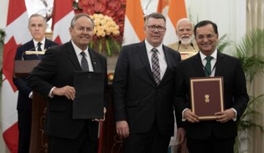 Prime Minister Mark Carney and Indian Prime Minister Narendra Modi look on as Saskatchewan Premier Scott Moe, centre, Cameco president Tim Gitzel, left, and High Commissioner of India to Canada Shri Patnaik participate in a presentation of agreements in New Delhi, India on Monday, March 2, 2026.  THE CANADIAN PRESS/Adrian Wyld
