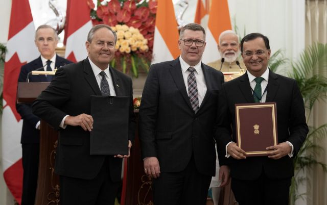 Prime Minister Mark Carney and Indian Prime Minister Narendra Modi look on as Saskatchewan Premier Scott Moe, centre, Cameco president Tim Gitzel, left, and High Commissioner of India to Canada Shri Patnaik participate in a presentation of agreements in New Delhi, India on Monday, March 2, 2026.  THE CANADIAN PRESS/Adrian Wyld