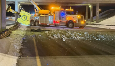 City crews clean up the aftermath of a semi-truck hauling equipment crashed into the Highway 11 overpass.