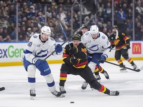 Professional hockey players skate towards the puck