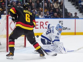 Tampa Bay Lightning goalie Andrei Vasilevskiy makes a save as Vancouver Canucks' Brock Boeser tries to make a shot on goal.