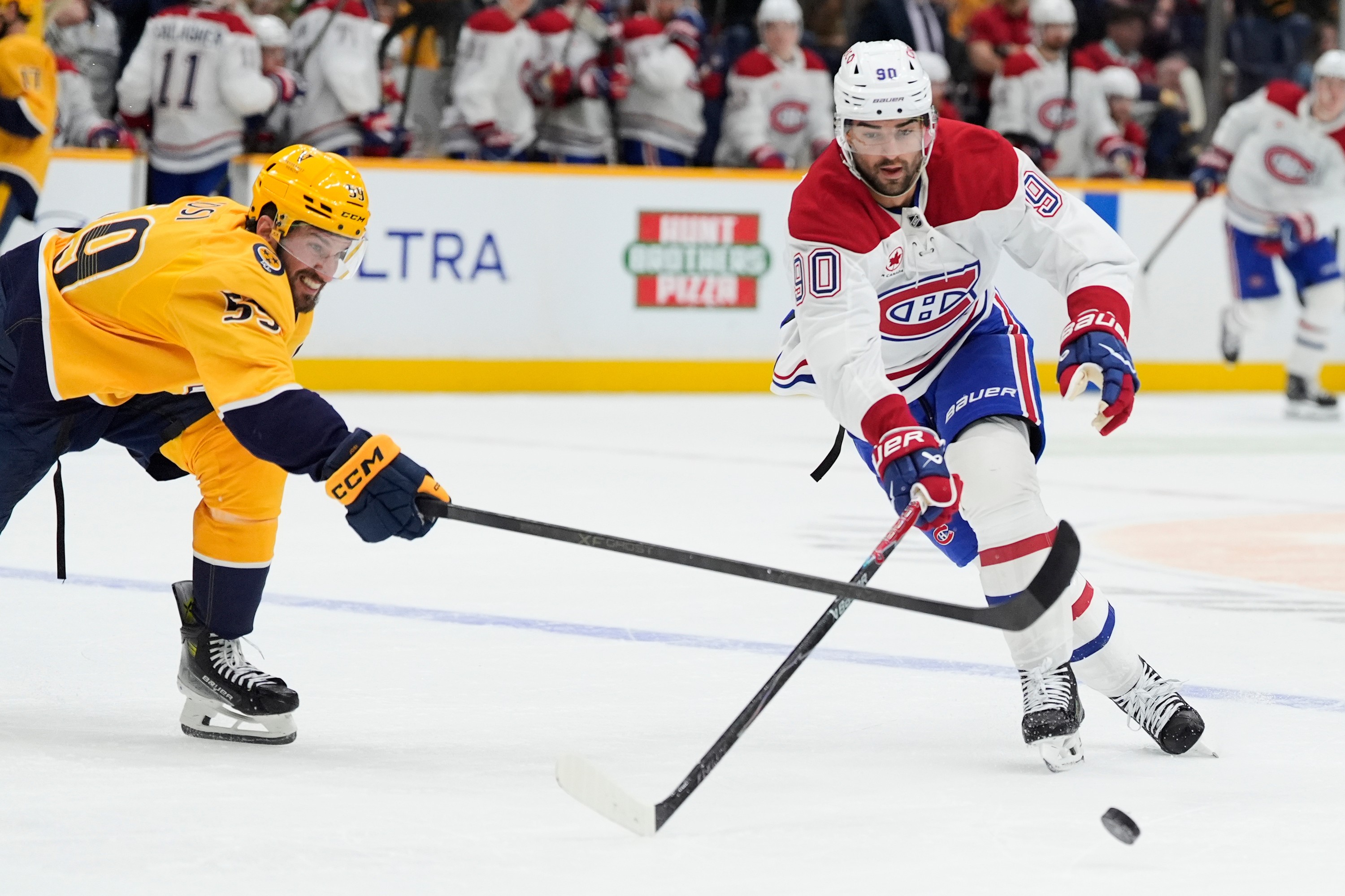 Hockey player skates past a defender.