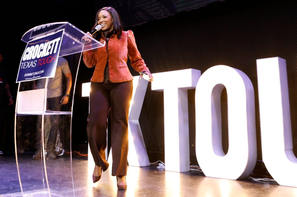 Rep. Jasmine Crockett takes the mic on stage at her Democratic primary election night in 2026.