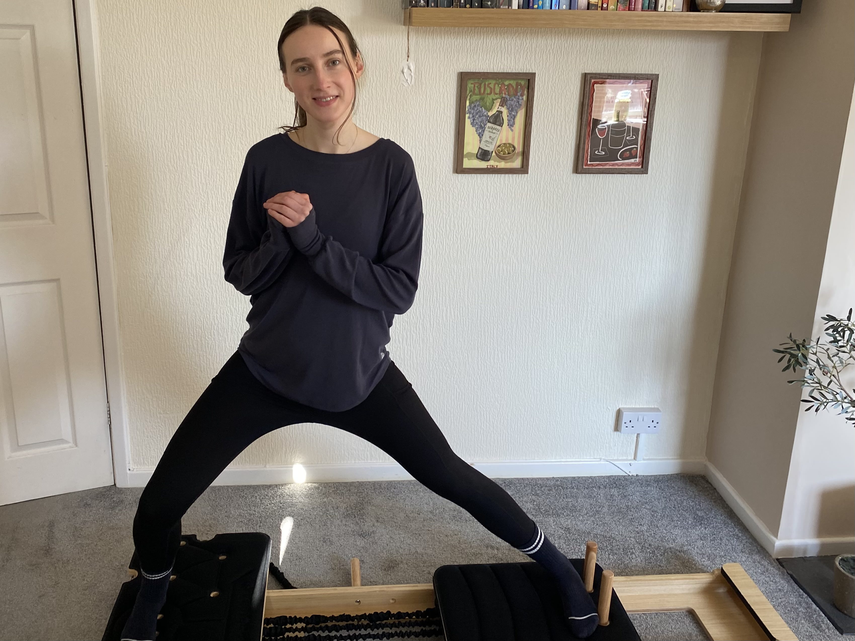 woman uses reformer pilates machine