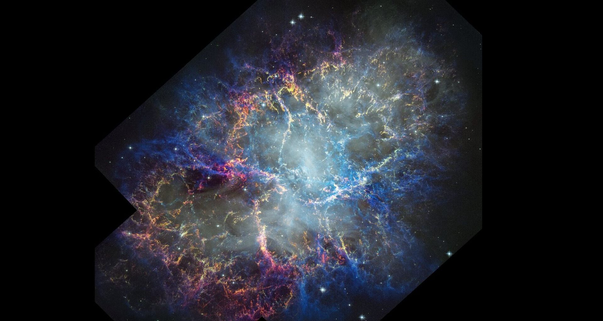 A glowing nebula of pink, blue and orange is seen in the darkness of space