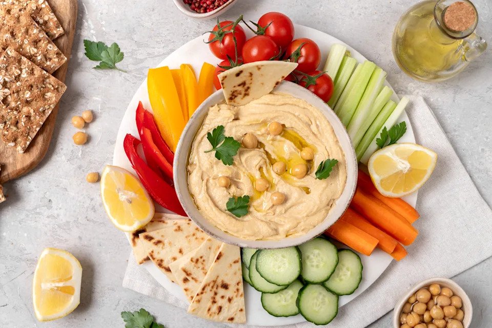 Overhead shot of hummus with paprika and vegetables.