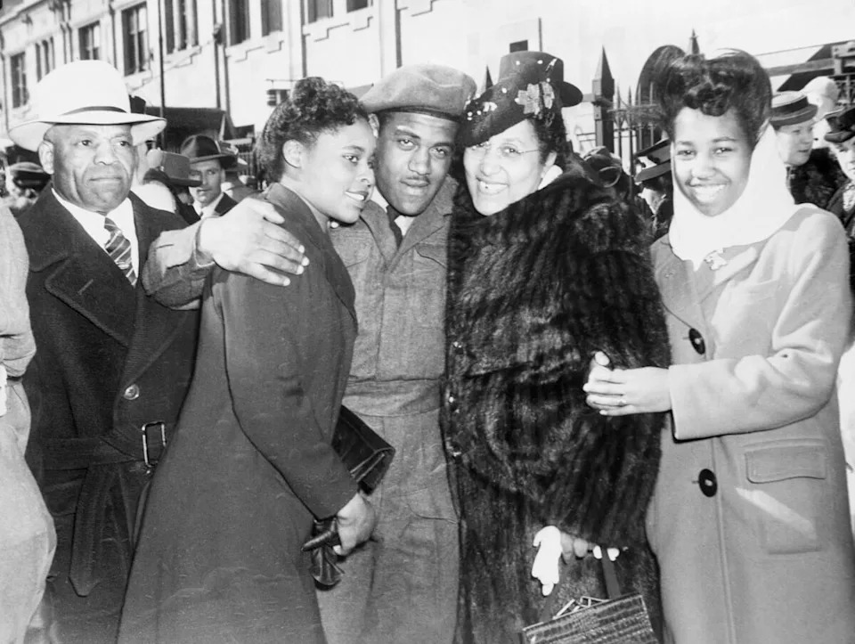 Corporal Theodore (Ted) King, pictured center, is met by his family on his return to Calgary. King was the president of the Alberta Association for the Advancement of Coloured People (AAACP) from 1958 to 1961.
