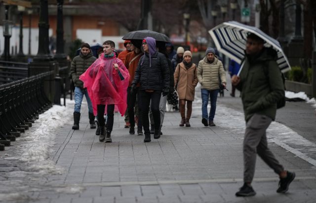 People walk along the seawall as rain falls in downtown Vancouver, Sunday, Dec. 25, 2022. THE CANADIAN PRESS/Darryl Dyck