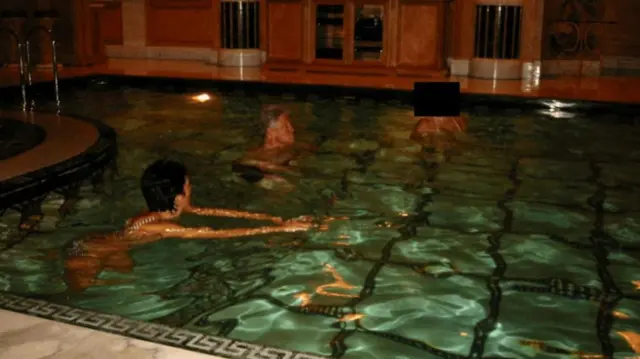 Bill Clinton swimming with an unknown person in a pool