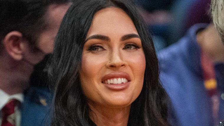 Megan Fox arches back in the sand wearing only pink floss for SI Swim