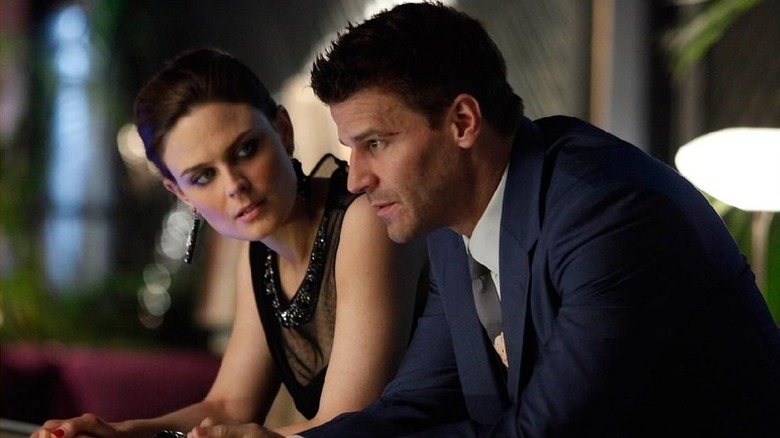 Brennan looking at Booth as they lean forward