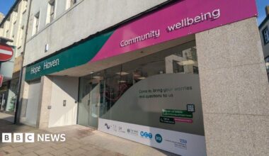 A general view of the Hope Haven hub. The premises are on the ground floor at the corner of a street. The front has large shop-style windows, partially frosted. A sign reads Hope Haven on a green and pink background.