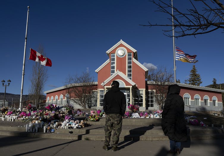 A building with two flagpoles with flags at half mast