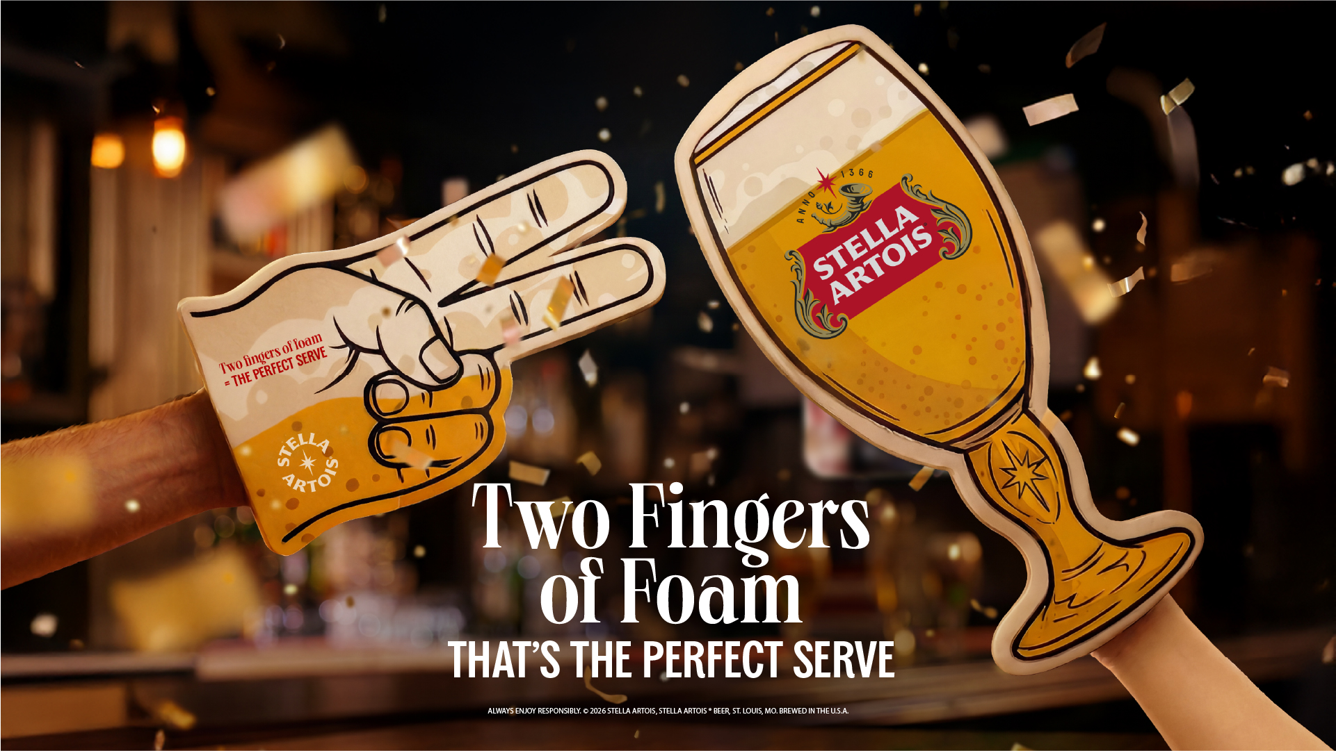 Two hands are seen wearing foam cutouts, one in the shape of a hand with two fingers extended and the other in the shape of a STELLA ARTOIS beer glass