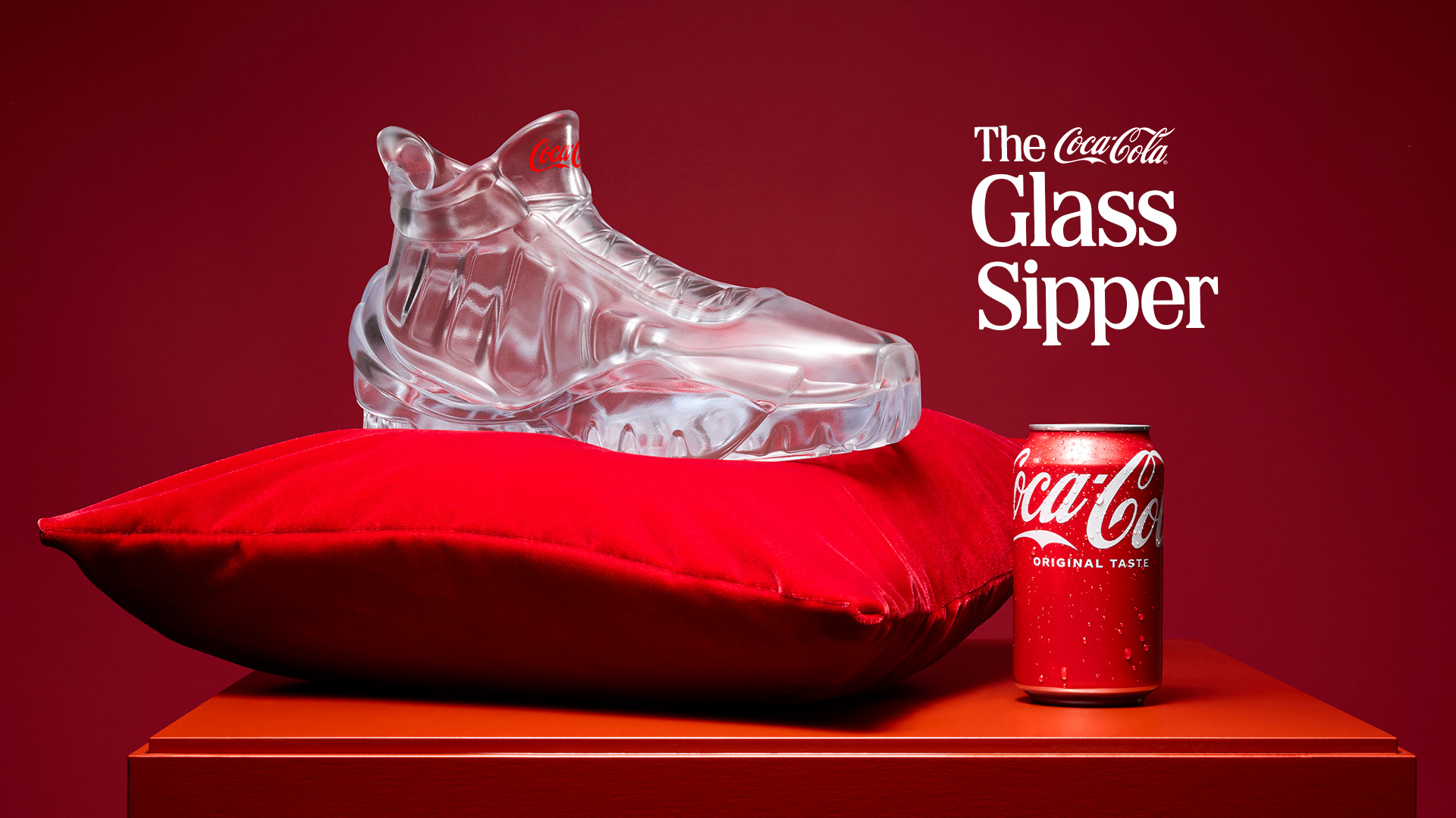 A glass sneaker-shaped cup next to a can of Coca-Cola