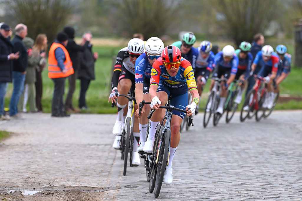 Pedersen leads a line of riders across some cobbles