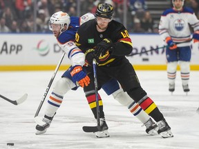Elias Pettersson (40) checks Edmonton Oilers' Connor McDavid (97) on Jan. 17, 2026.