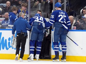 Maple Leafs forward Auston Matthews is helped off the ice