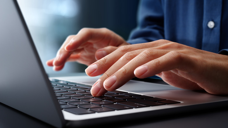 Closeup of Hands typing on laptop