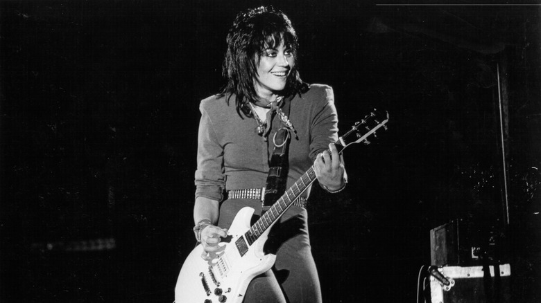 Joan Jett performs on stage and plays guitar