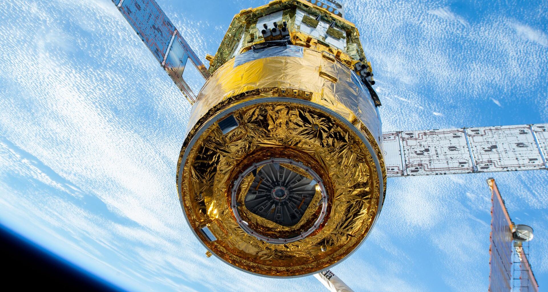 The new HTV-X1 cargo spacecraft from JAXA (Japan Aerospace Exploration Agency), carrying approximately 12,800 pounds of science, supplies, and hardware for the Expedition 73 crew, is pictured after being captured by the Canadarm2 robotic arm. The Common Berthing Mechanism, located at the base of HTV-X1, is visible and serves as the interface that attaches the spacecraft to the Earth-facing port on the International Space Station’s Harmony module, enabling crew access to the cargo inside.